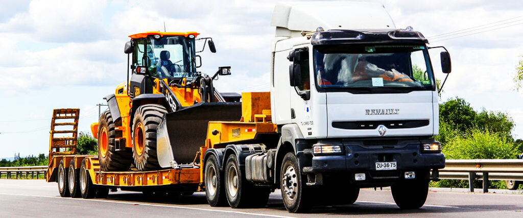 A bulldozer is transported by a truck