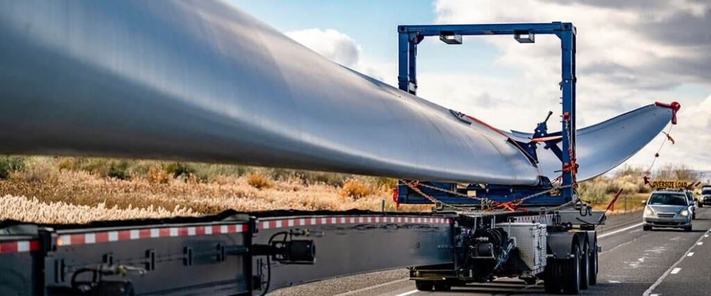 A turbine blade being hauled on an extremely long trailer
