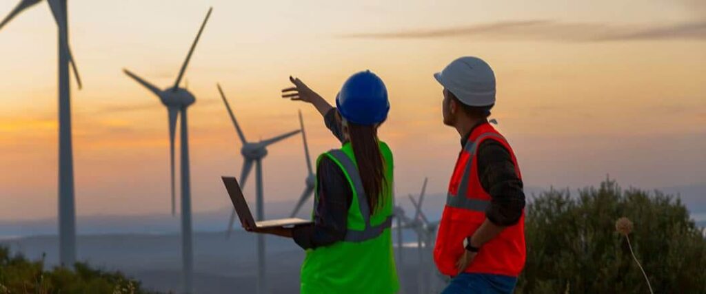 Two workers inspecting a wind farm