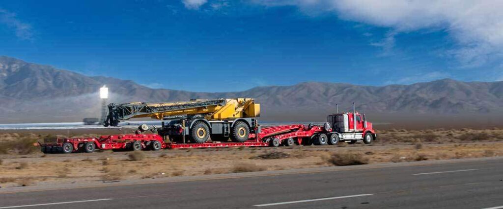 step-deck trailer hauling a large construction vehicle
