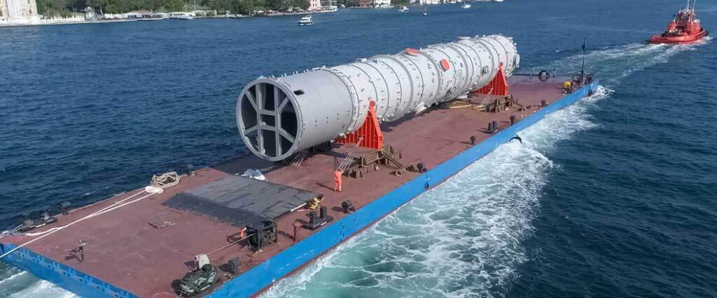 An oversized cylinder on a large barge