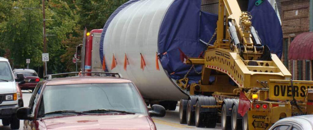 A semi truck transporting a large cylindrical object 