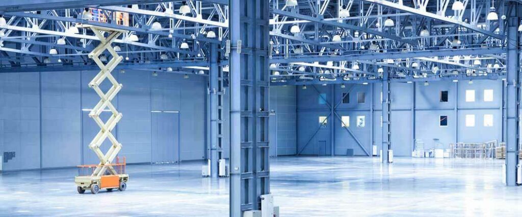  An extended scissor lift inside an empty warehouse